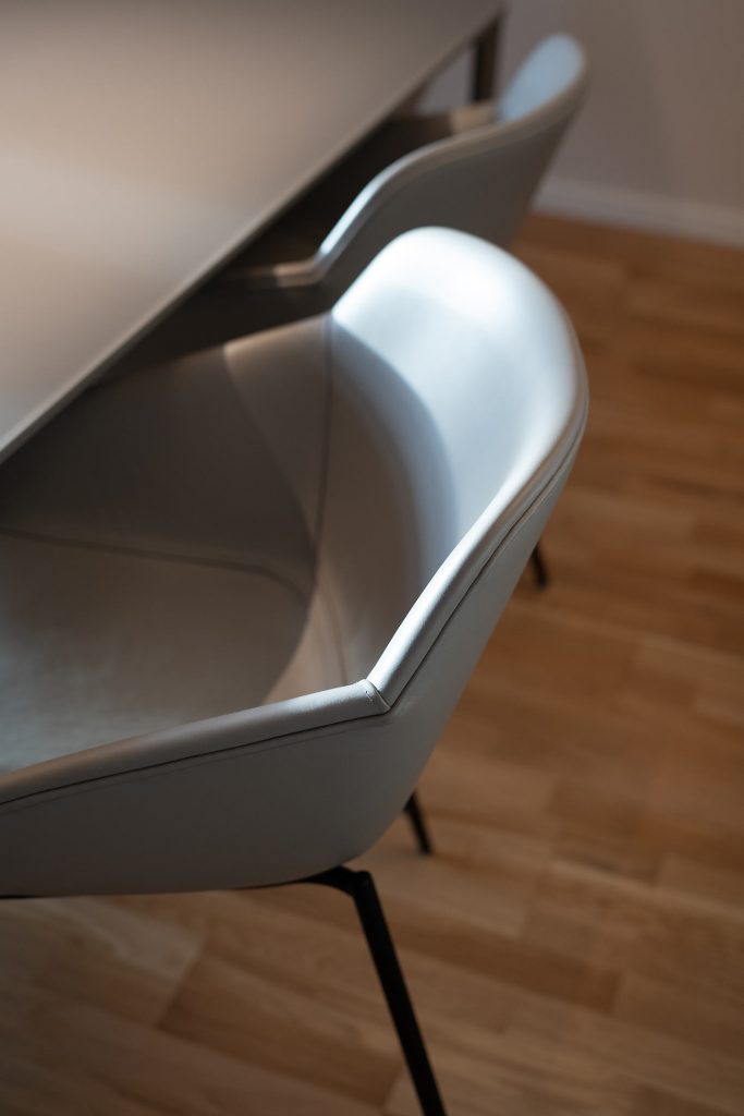 Nahaufnahme eines grauen Lederstuhls im Essbereich