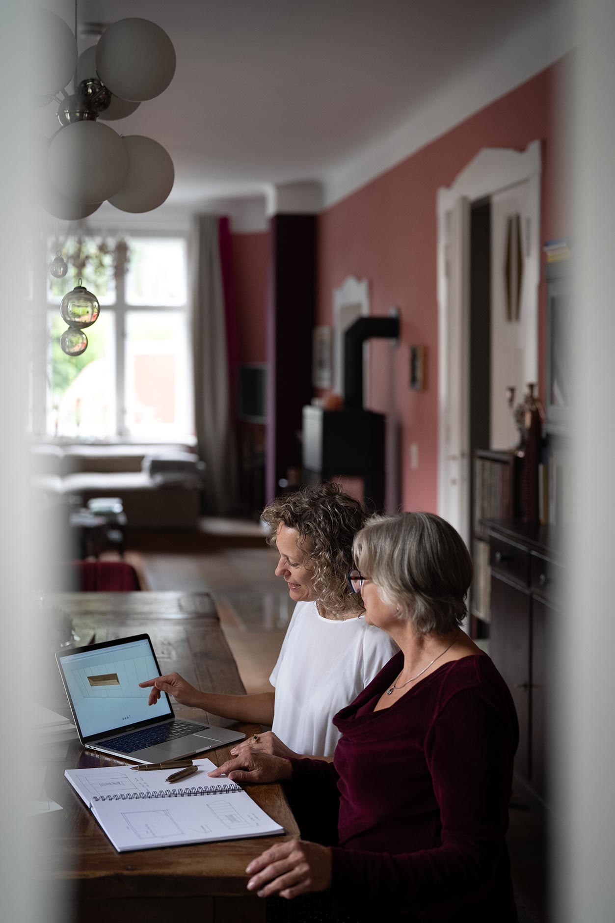 Consultation and on-site measurement for a custom-made piece of furniture – discussion with a client at the table