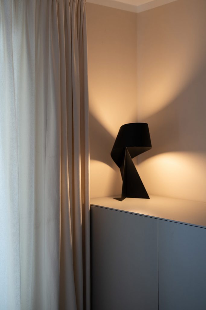 Black table lamp on a custom-made sideboard in the bedroom