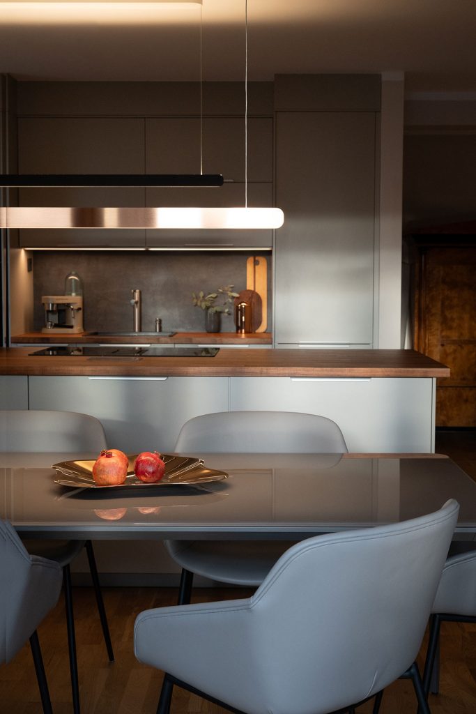 Dining area with glass table by Sovet, leather chairs by BoConcept and lamp by Occhio – Hansen Interior Design Berlin & Brandenburg